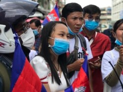 កញ្ញា​ ជា គន្ធីន​ វ័យ​១៨ ឆ្នាំ​ រាប់ពី​ខាង​ឆ្វេង​ដៃ ឈរ​នៅ​កណ្តាល។ (ហ៊ុល រស្មី/វីអូអេ)