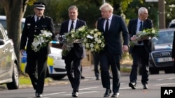 Britanski premijer Boris Džonson i lider opozicione Laburističke partije Keir Starmer nose cveće na mestu ubistva poslanika Dejvida Amesa, u mestu Leng-on-Si, Eseks, Engleska, 16. oktobar 2021.