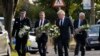 British Prime Minister Boris Johnson and leader of the Labour Party Keir Starmer, second from left, carry flowers as they arrive at the scene where member of parliament David Amess was stabbed Friday, in Leigh-on-Sea, Essex, England, Oct. 16, 2021. 