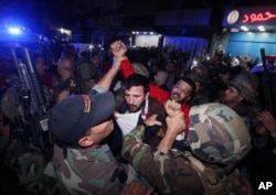 Lebanese soldiers arrest a suspected attacker near the scene of a twin suicide attack in Burj al-Barajneh, a predominantly Shi'ite suburb of southern Beirut, Lebanon, Nov. 12, 2015.