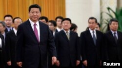 លោក​ប្រធានាធិបតី​ចិន Xi Jinping ដើរនៅ​ពី​មុខ​ក្រុម​មន្រ្តី​​ជាន់​ខ្ពស់​ចិន​ក្នុង​​អំឡុង​នៃ​ពិធីស្វាគមន៍​មួយ​នៅឯ​មហា​សាល​នៃប្រជា​ជននៅ​ក្នុង​ទីក្រុង​ប៉េកាំង​ កាល​ពីថ្ងៃទី​៩ ខែ​ធ្នូ​ ឆ្នាំ​២០១៤។ 