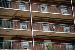A student stands on the balcony of Ehringhaus dormitory on campus at the University of North Carolina in Chapel Hill, N.C., Aug. 18, 2020.