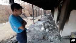 Justin Kam surveys his destroyed home at Balmoral, Australia, Jan. 7, 2020. 