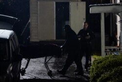 FILE - A body is removed from Gold Spa massage parlor after a shooting, in Atlanta, Georgia, late March 16, 2021.