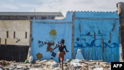 Un enfant joue dans les décombres de maisons démolies à Xwlacodji, dans le 5ème arrondissement de Cotonou, le 3 septembre 2019, après le passage des bulldozers.