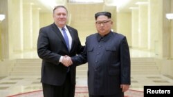 Pemimpin Korea Utara Kim Jong Un berjabat tangan dengan Menteri Luar Negeri AS Mike Pompeo dalam foto yang dirilis 9 Mei 2018 oleh Kantor Berita Pusat Korea (KCNA) milik pemerintah Korea Utara di Pyongyang.