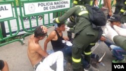A Colombian police officer helps men who were hurt in clashes at the Simon Bolivar Bridge on the Colombia-Venezuela border near Cucuta.