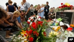 Warga setempat meletakkan karangan bunga untuk mengenang para korban Malaysian Airlines yang ditembak jatuh dekat Desa Hrabove, Wilayah Donetsk, bagian timur Ukraina, 17 Juli 2017. 