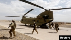 FILE - U.S. troops walk from a Chinook helicopter in Uruzgan province, Afghanistan, July 7, 2017. 