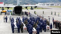 FILE - Military personnel unload a coffin with the remains of Brazilian victims who died in a plane crash in the Colombian jungle with Brazilian soccer team Chapecoense. The bodies were flown home to Brazil, Dec. 2, 2016.