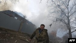 អ្នក​ពន្លត់​អគ្គីភ័យ​ដើរ​ចេញ​ពី​ផ្ទះ​មួយ​ចំនួន​ដែល​ខូច​ខាត​ដោយ​គ្រាប់​ផ្លោង នៅ​ភាគ​ខាង​កើត​ប្រទេស​អ៊ុយ​ក្រែន នៅ​ក្នុង​ទី​ក្រុង Donetsk កាល​ពី​ថ្ងៃ​ទី​៣ ខែ​កុម្ភៈ ឆ្នាំ​២០១៥។