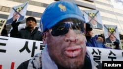 A protester wearing a mask depicting former U.S. basketball star Dennis Rodman, attends a rally in central Seoul, South Korea, Jan.8, 2014, denouncing Rodman's visit to North Korea and North Korean leader Kim Jong Un on Kim's birthday. 