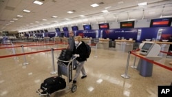 Penumpang yang bernama Gisela Sanchez dan Sael Sayago berjalan dari konter tiket Delta di Bandara Internasional Salt Lake City Selasa, 7 April 2020, di Salt Lake City, dalam ilustrasi. (Foto: AP)