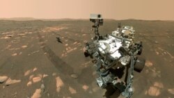 This Tuesday, April 6, 2021 image made available by NASA shows the Perseverance Mars rover, foreground, and the Ingenuity helicopter about 13 feet (3.9 meters) behind. This composite image was made by the WASTON camera on the rover's robotic arm on…