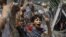 An Egyptian boy peers out of barbed wire during a protest in front of the Supreme Constitutional Court in Cairo, Egypt, Thursday June 14, 2012.
