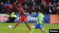 Armando Cooper de Toronto FC frappe la balle face à Cristian Roldan des Seattle Sounders, Canada, le décembre 2017.