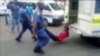 A South African man with his hands tethered to the back of a police vehicle being dragged behind as police hold his legs up and the vehicle apparently drives off, east of Johannesburg, Feb. 26, 2013. The man died of his injuries.