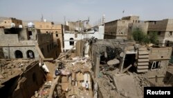 People check damage at the site of a Saudi-led airstrike in Amran, Yemen, June 25, 2018.
