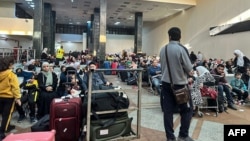 Watu wanaojaribu kukimbia kutoka Ukanda wa Gaza wasubiri kwenye kivuko cha mpakani cha Rafah upande wa Misri.