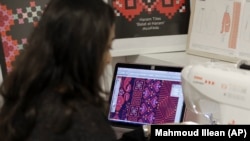 In this Tuesday, January 29, 2019 photo, thobe designer Natalie Tahhan works in her studio in east Jerusalem.