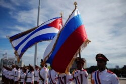 Honor guards hold a Russian and a Cuban flag during a wreath-laying ceremony with Russia's Prime Minister Dmitry Medvedev (not pictured) at the Jose Marti monument in Havana, Cuba, Oct. 3, 2019.