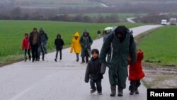 Migrants walk along a road from the village of Chamilo to the migrant camp at the village of Idomeni, near the Greek-Macedonian border, Greece, March 15, 2016.
