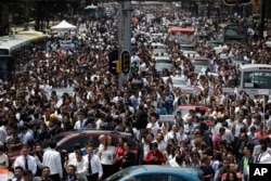 People evacuated from office buildings gather in Reforma Avenue after an earthquake in Mexico City, Sept. 19, 2017.