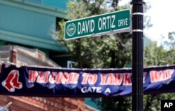 A new "David Ortiz Drive" street sign is posted outside Fenway Park, after a ceremony where part of Yawkey Way was renamed, June 22, 2017, in Boston. Ortiz's No. 34 was retired in a ceremony prior to a game later that day.