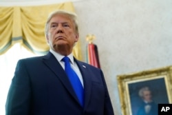 FILE - President Donald Trump listens to a reporter's question at an event in the Oval Office of the White House, in Washington, Dec. 7, 2020.
