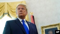 Presiden Donald Trump mendengarkan pertanyaan para wartawan dalam sebuah acara di Oval Office, Gedung Putih di Washington, 7 Desember 2020.