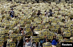 Japanese protesters raise placards reading 'Anger was over the limit' during a rally against U.S. military bases, following the arrest of an American suspected of murdering a local woman, June 19, 2016.