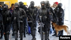 FILE - Members of Brazil's Battalion of Special Operations (BOPE) participate during a crisis simulation exercise conducted by the BOPE to show the media how security will be provided during the 2016 Olympics at the Golf Olympic bus station in Rio de Janeiro, Feb. 11, 2015.