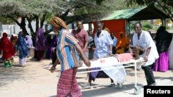 Des secours évacuent les victimes d'un attentat dans le quartier de Hodan, à Mogadiscio, le 15 octobre 2017.