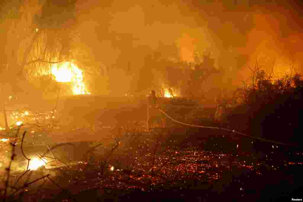 Firefighters put out a fire in an open field, following a mass-infiltration by Hamas gunmen from the Gaza Strip, near a hospital in Ashkelon, southern Israel, Oct. 7, 2023.