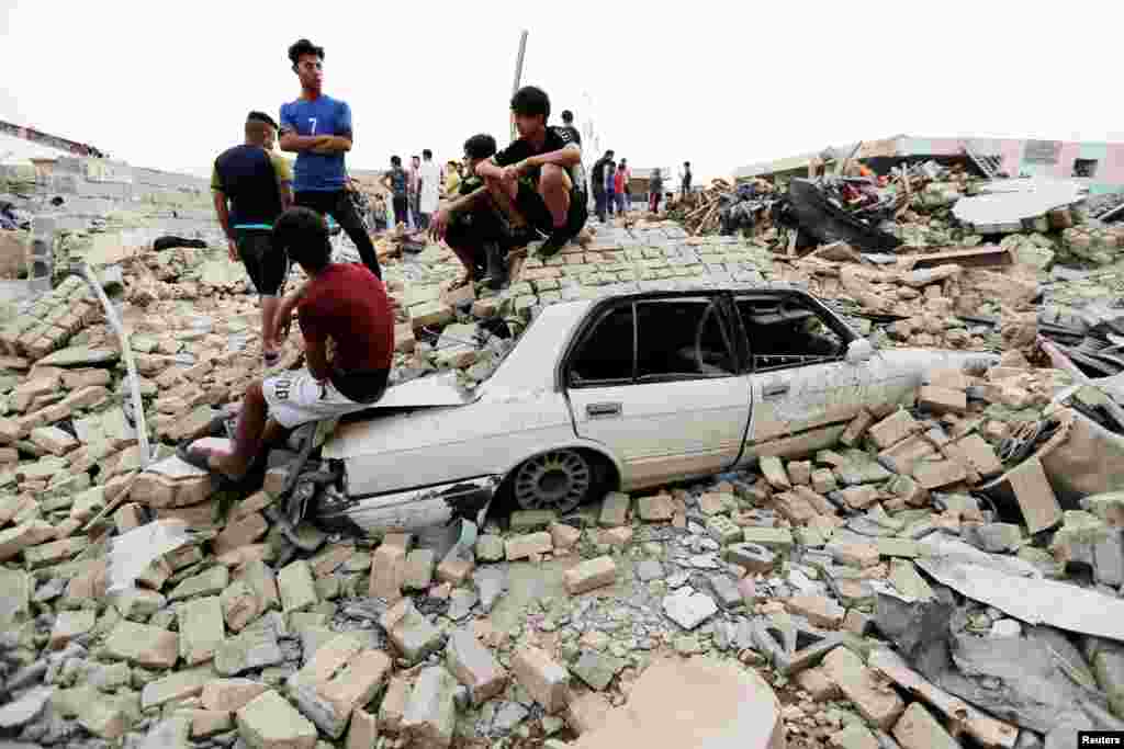 People gather at the site of an explosion in Baghdad&#39;s Sadr City district, Iraq.