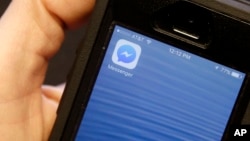 FILE - This mobile phone shows the Facebook Messenger app icon. Users of the app can now play games with it.