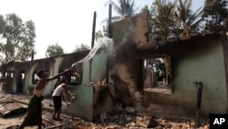 Okkan qishlog'ida musulmonlar buddistlar chiqargan yong'inni o'chirishga harakat qilmoqda, Birma, 1-may, 2013-yil