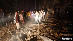 Warga dan petugas penyelamat di lokasi pemboman di kota Karachi, Pakistan hari Minggu (3/3). 