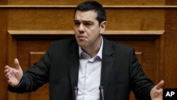 Greek Prime Minister Alexis Tsipras speaks in parliament before the vote of an anti-poverty bill, the first piece of legislation from the left-wing government, in Athens, March 18, 2015.