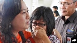 Relatives of AirAsia passengers wait at the airport in Surabaya, Indonesia, for news about the lost plane.