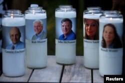 Candles representing the slain journalists of Capital Gazette sit on display during a candlelight vigil held near the Capital Gazette, the day after a gunman killed five people inside the newspaper's building in Annapolis, Maryland