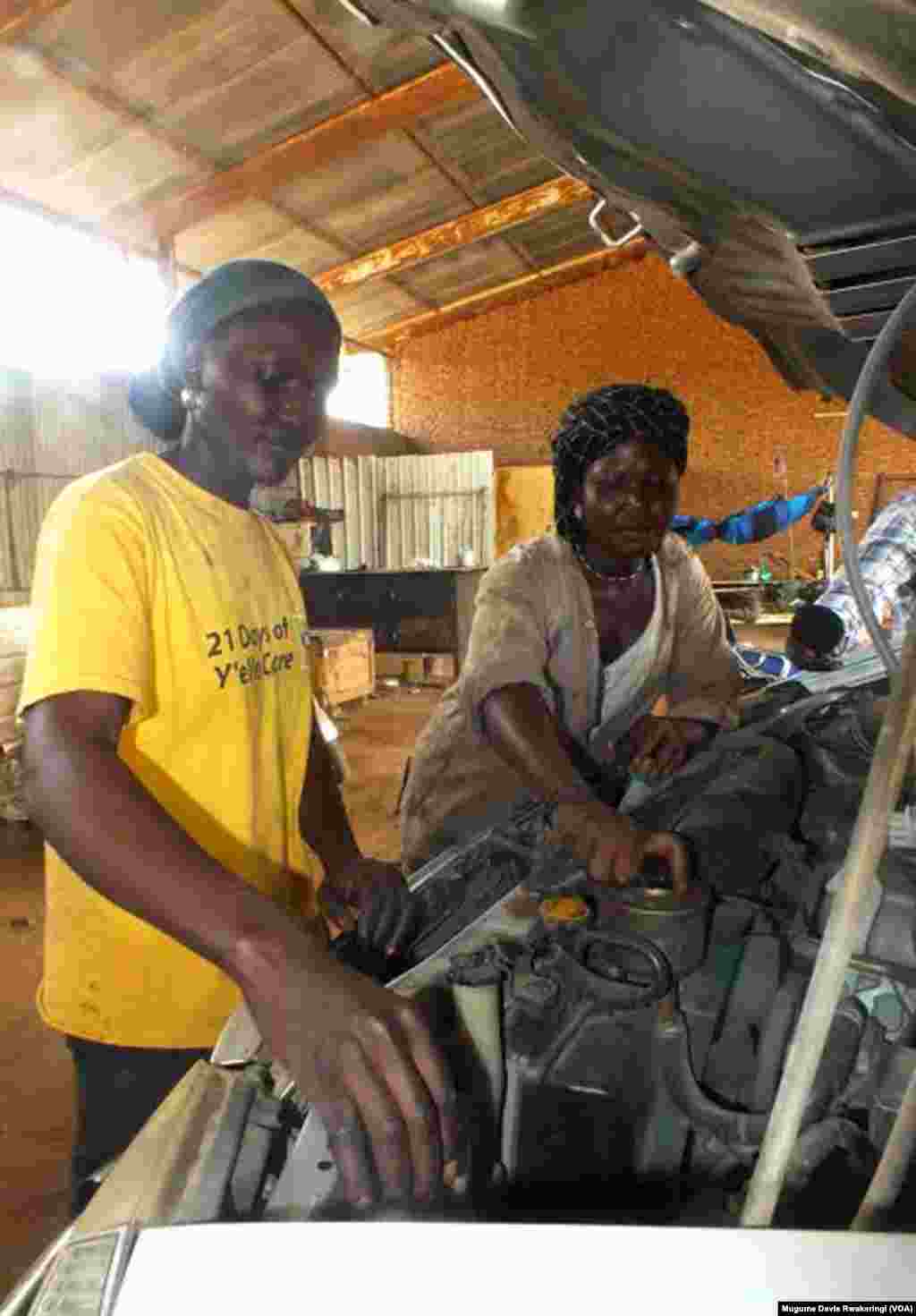 Car mechanics Elizabeth Yacob (L) and Diane Andrew service a vehicle at the University of Juba Auto Garage in the South Sudan capital. 