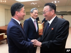 FILE - South Korean Unification Minister Hong Yong-pyo, left, shakes hands with Kim Yang Gon, a senior North Korean official responsible for South Korean affairs, after their meeting at Panmunjom. Yang Gon recently died in a car crash.