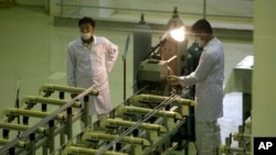 伊朗技术人员在生产铀燃料的设施前工作。（2009年4月9日）