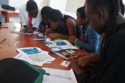 Connecting wires, campers learn how traffic robots are made and programmed. (VOA/Lameck Masina)