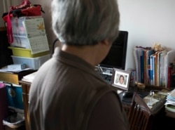 In this photo taken April 29, 2014, Zhang Xianling looks across to a photo of her son Wang Nan who was killed in a 1989 military crackdown during an interview at her home in Beijing, China.