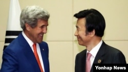 지난해 7월 라오스 비엔티안에서 열린 미-한 외교장관 회담에서 존 케리 미 국무부 장관(왼쪽)이 윤병세 한국 외교장관과 악수하고 있다. (자료사진)