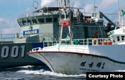 A Paluan law enforcement ship suspects a Taiwanese long line fishing vessel of illegal shark finning in Palau’s Exclusive Economic Zone, in violation of Palau’s law banning such fishing. (Alex Hofford/Greenpeace)