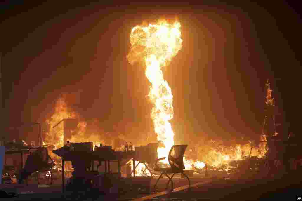 A fire set by protesters burns at the Hong Kong Polytechnic University campus in Hong Kong, Monday, Nov. 18, 2019. Hong Kong police using tear gas and rubber bullets fought off protesters Monday as they tried to break through a police cordon that is trapping hundreds of them on a university campus. (AP Photo/Kin Cheung)