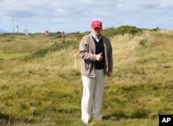 FILE - Donald Trump gestures to the media on the Turnberry golf course in Turnberry, Scotland, July 30, 2015.